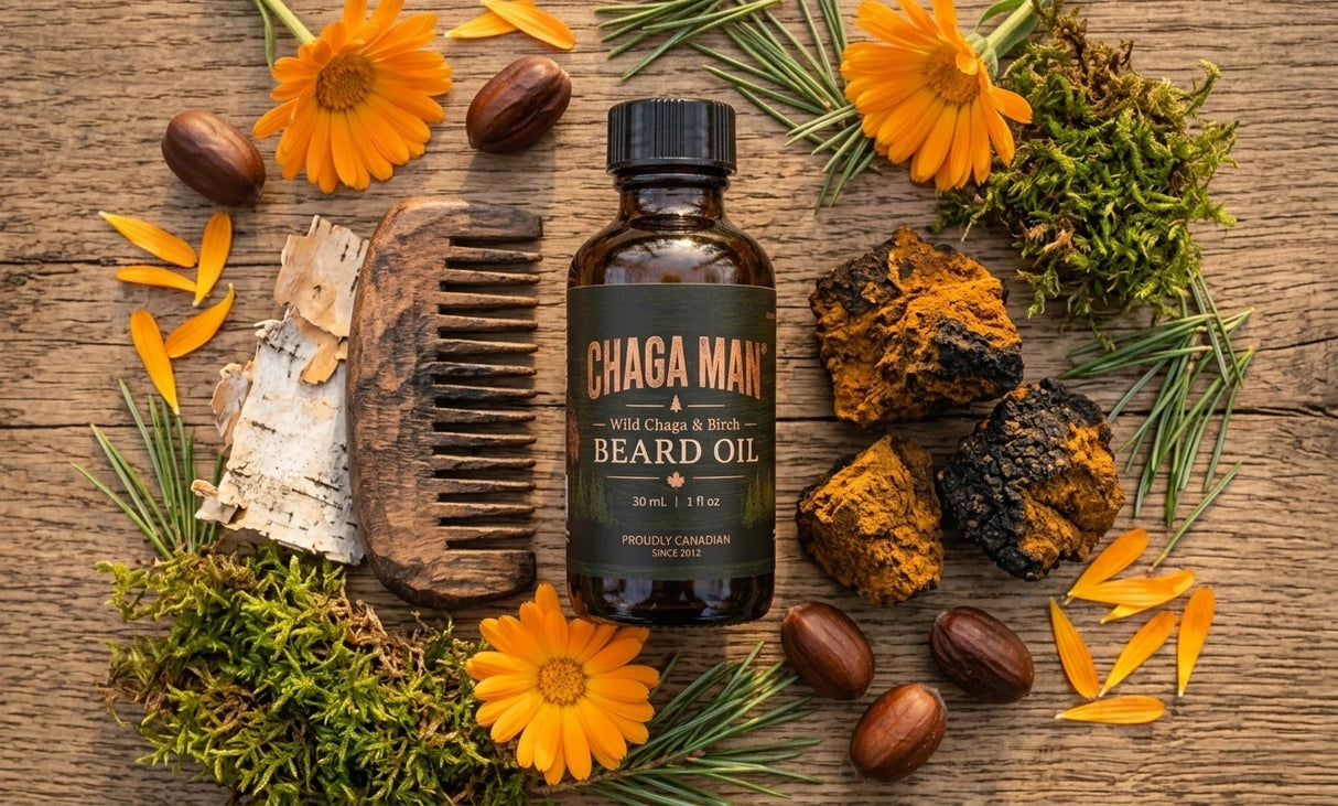 Chaga Man Beard Oil in an amber glass bottle with a black cap, styled on a rustic wooden background with orange flowers, acorns, moss, birch bark, and a wooden comb.